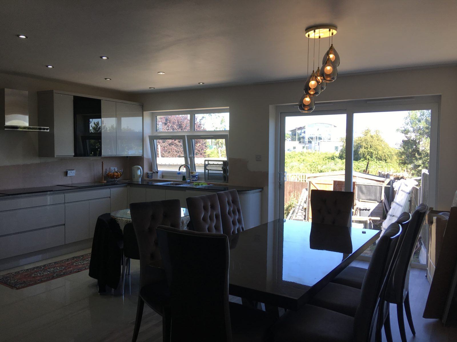 Kitchen and dining space opening to the garden through full-height glazing