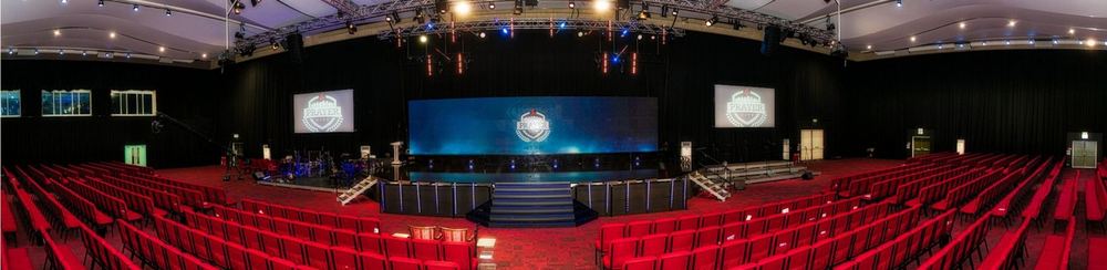 The completed Prayer Palace auditorium, tiered red seating facing a lit stage