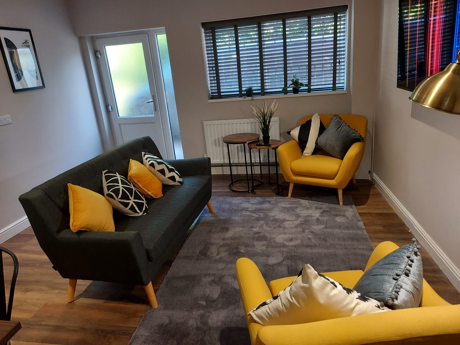 Completed living room with mustard armchairs and plantation shutters